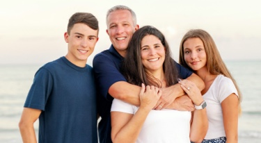 Family of 4 on a beach. Mother, father, son, and daughter.